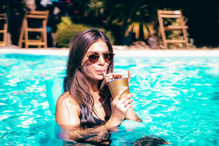 Woman in pool with a cool drink