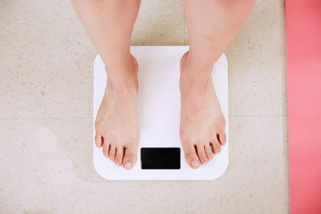 A person checking their body weight with a scale