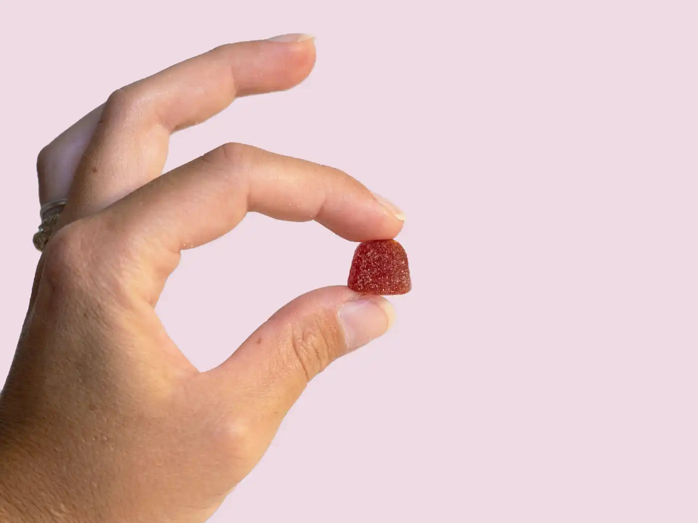 A hand holding a CBD gummy from Nordic Oil